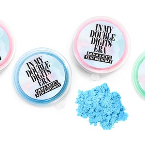 May include: Three small containers of blue, pink, and green slime with labels that say "In My Double Digits Era" and "Emma Kate's 13th Birthday".