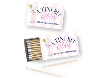 May include: A pink and white striped matchbox with a martini glass illustration and the text "A Tini Bit Older" and "Sarah's 25th Birthday".