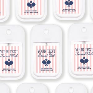 multiple white spray bottles with pink and blue stripes and text, all labeled with the same design.