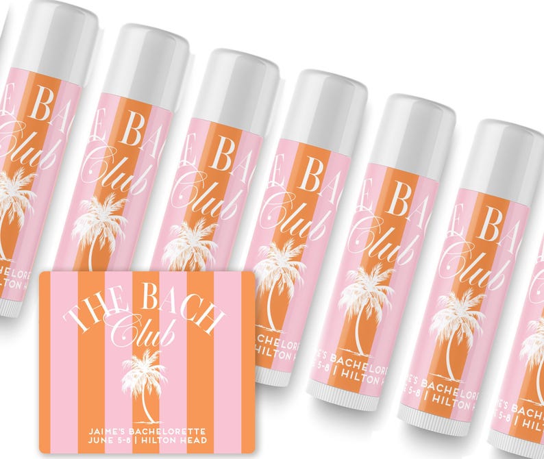 a collection of pink and white tubes of lip balm arranged in a row, with a pink and white striped card in the foreground.