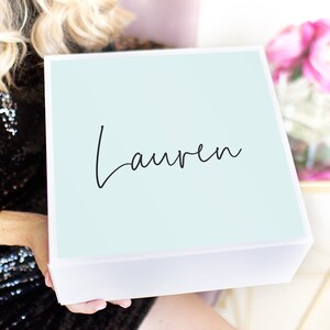 May include: A white gift box with a light blue lid. The lid has the name "Lauren" written in black cursive script.
