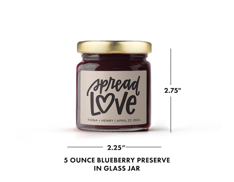 May include: A small glass jar of blueberry preserve with a gold lid. The label reads "Spread Love" with a heart, and the names Fiona & Henry, and the date April 27, 2024. The jar is 2.25 inches wide and 2.75 inches tall.