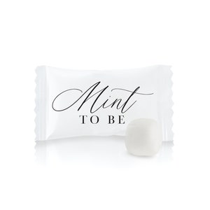 May include: White mint candy in a white wrapper with the text "Mint to Be" in black script.