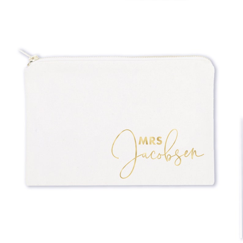 May include: White canvas zippered pouch with gold lettering that reads "MRS Jacobsen".