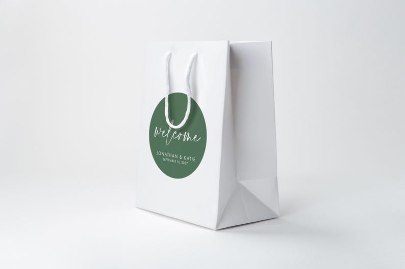 A white paper bag with a green circular sticker that says "Welcome Jonathan & Kate September 16, 2020" printed on it.
