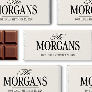 May include: Chocolate bars with a light-colored wrapper, featuring the text "The Morgans," "Loft Lucia," and the date "September 25, 2029" in black. A portion of a chocolate bar is visible on the left.