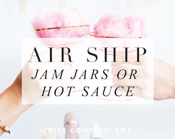 May include: Two pink cotton candy filled champagne glasses with gold rims. The text "AIR SHIP JAM JARS OR HOT SAUCE" is superimposed on the image. The text "WHITE CONFETTI BOX" is at the bottom of the image.