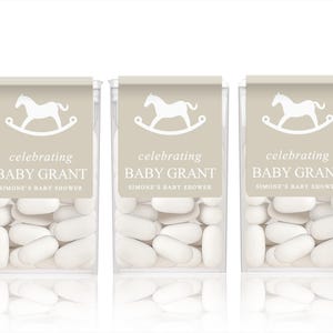 May include: Five clear plastic containers filled with white mints. Each container has a beige label with a white rocking horse and the text "celebrating Baby Grant Simone's Baby Shower".