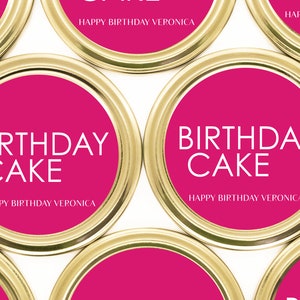 以下が含まれることがあります： 「バースデーケーキ」と「ハッピーバースデーベロニカ」の文字が書かれた、ピンクとゴールドの丸いラベル4枚のクローズアップ。