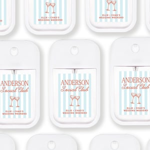 multiple identical white spray bottles with blue and orange stripes and text, arranged in a grid-like pattern.