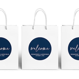 Three white paper bags with blue circular logos and text, arranged in a row.