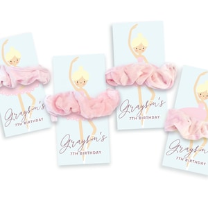 May include: Four pink and white ballerina-themed party favour tags with the text "Grayson's 7th Birthday" and a pink velvet scrunchie attached to each tag.