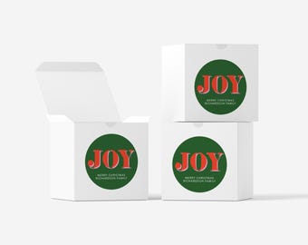 May include: White gift boxes with a green circle featuring the word "JOY" in red, with "MERRY CHRISTMAS RICHARDSON FAMILY" below. One box is open, revealing the inside. The boxes are stacked and arranged on a white surface.