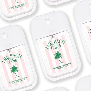multiple identical white spray bottles with pink and green labels, each featuring the text "The BAC CLUB" and "TANYA BACULOYETTE MAY 22-24 JAMAICA" printed on them.