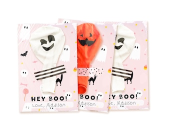 May include: Three Halloween-themed party favor cards featuring uninflated balloons attached with patterned tape. Two white balloons have ghost faces, and one orange balloon has a jack-o'-lantern face. Cards show ghosts, bats, and the text HEY BOO! Love, Madison.