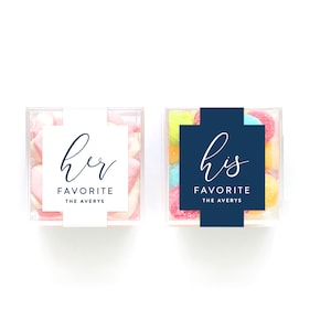 May include: Two clear plastic containers filled with candy. One container has pink and white candy with a white label that says "her favorite the averys". The other container has multi-colored candy with a navy blue label that says "his favorite the averys".