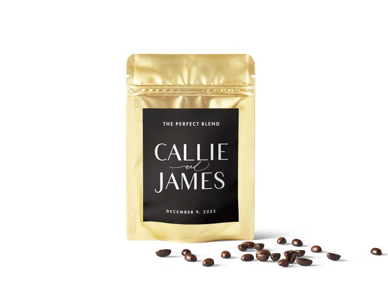 Puede incluir: Una bolsa de papel de aluminio dorado con una etiqueta negra que dice "The Perfect Blend" y "Callie and James" con la fecha "December 9, 2023". Granos de caf&eacute; esparcidos sobre una superficie blanca.