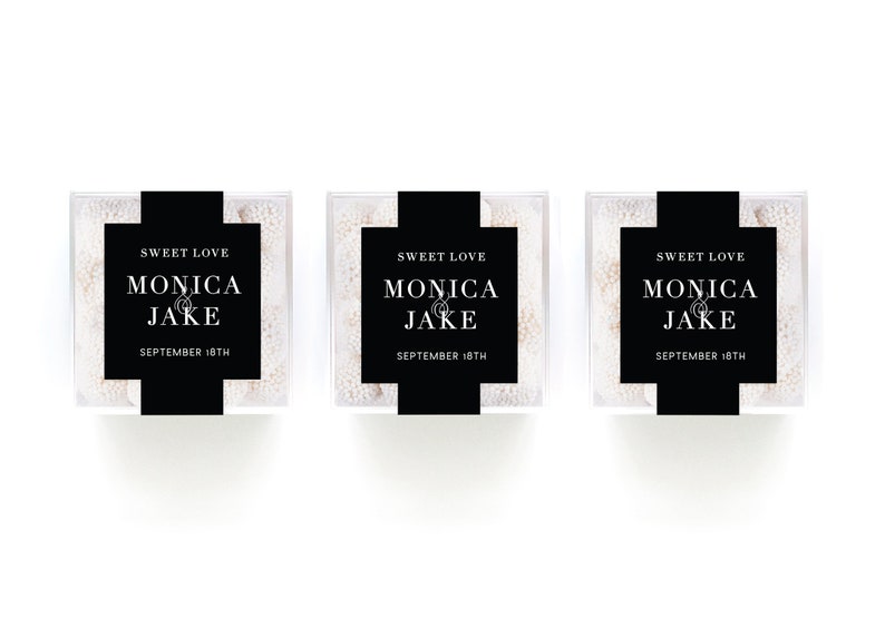 May include: Three clear boxes filled with white candy, each with a black label that reads "Sweet Love Monica & Jake September 18th".