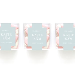 May include: Three clear boxes filled with pink and white marshmallows. Each box has a light blue label with the text "OH BABY! KATIE & SAM BABY THOMAS".
