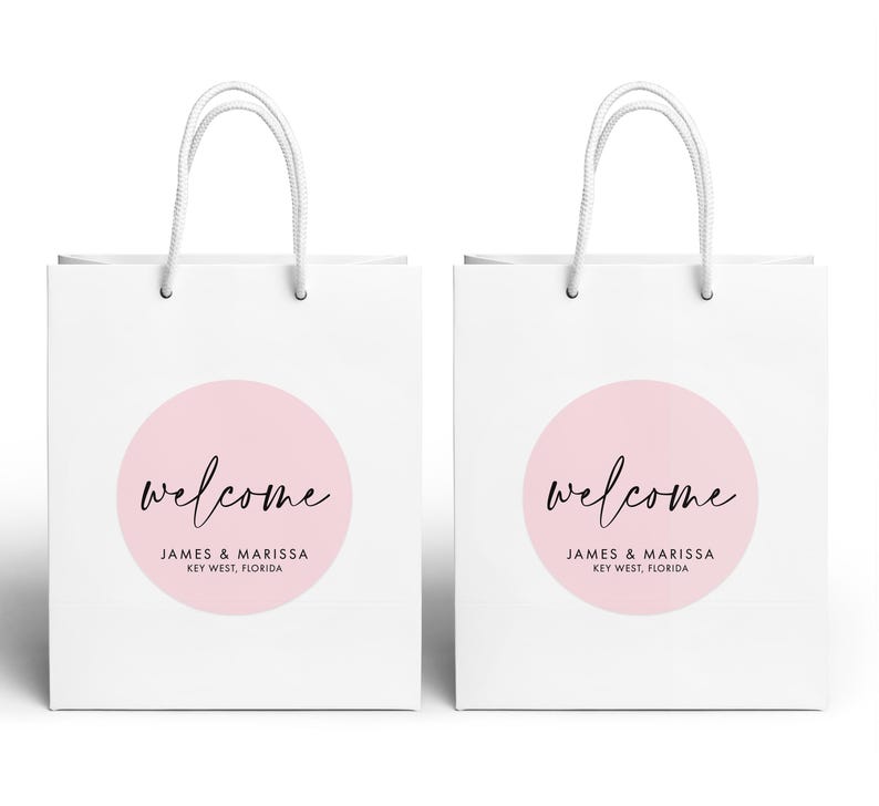 two white paper shopping bags with the word "Welcome" printed on them.