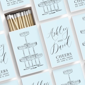 a collection of light blue cards with illustrations of champagne glasses and text that reads "Ashley and David". The cards are arranged in a grid-like pattern, with some cards overlapping each other.
