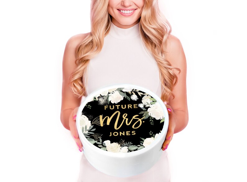 May include: A white round box with a black and white floral design and gold lettering that says "Future Mrs. Jones".