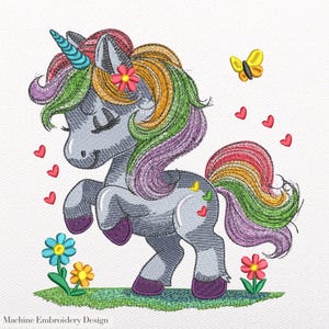 May include: An embroidered design of a gray unicorn with a rainbow mane and tail, a blue horn, and a pink flower. The design includes red hearts, a yellow butterfly, and colorful flowers. The text "Machine Embroidery Design" is at the bottom.