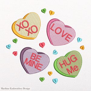 May include: An embroidered design featuring four heart-shaped candies with messages: "XO XO", "LOVE", "BE MINE", and "HUG Me". Small heart accents in various colors surround the candies. The design is on a white background.