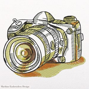 Könnte beinhalten: Gesticktes Design einer Kamera mit großem Objektiv, dargestellt in gelbem, braunem und schwarzem Garn. Das Design hat ein skizzenhaftes Aussehen mit sichtbaren Stichlinien. Der Text "Machine Embroidery Design" befindet sich unten.
