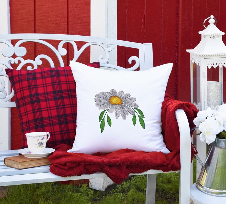 Daisy embroidery design featured on acushion.
