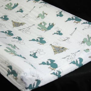 May include: White changing pad cover with a green and brown cactus and teepee print. The text "be brave" is repeated on the cover.