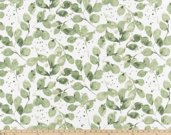 May include: A white fabric with a green watercolor leaf pattern. The leaves are scattered randomly across the fabric and have a slightly textured look.