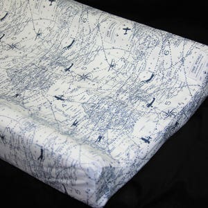 May include: A white changing pad with a blue and white world map print. The pad has a blue border and the text "THE WORLD" is printed in the top right corner.