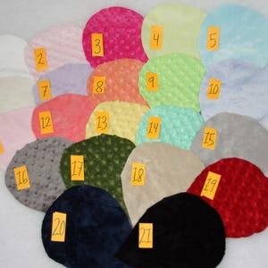 May include: Twenty-one fabric swatches in various colors and textures, including solid colors, textured patterns, and a few with a subtle sheen. The swatches are numbered 1 through 21.