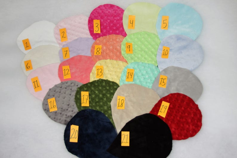 May include: Twenty-one fabric swatches in various colors and textures, including solid colors, textured patterns, and a few with a subtle sheen. The swatches are numbered 1 through 21.