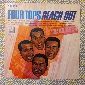 Puede incluir: Una portada de álbum de vinilo vintage con una foto del grupo de canto The Four Tops. El título del álbum es "Reach Out" y la discográfica es Motown. La portada del álbum está en tonos de naranja, rosa y blanco.