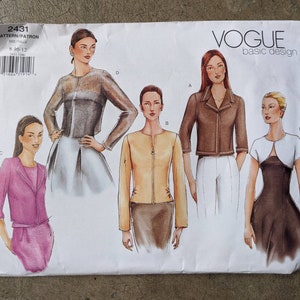 May include: Vogue Basic Design sewing pattern 2431. The pattern features illustrations of women's jackets and a dress. The pattern envelope is white with the Vogue logo and pattern details. The size range is 8-10-12.