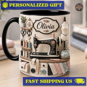 May include: A cream-colored ceramic mug with a black handle and interior, featuring a 3D-style design of a sewing room. It displays a sewing machine, spools of thread, a mannequin, a pincushion, buttons, fabric swatches, and a sign reading Olivia.