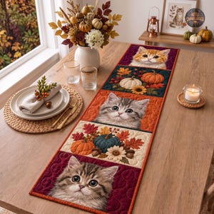 May include: A rectangular quilted table runner featuring alternating panels of kittens and autumn harvest motifs. The design includes three kitten portraits and two panels with pumpkins, sunflowers, and fall leaves in shades of orange, red, and teal.
