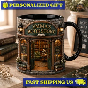May include: A ceramic mug shaped like a bookstore facade with a black handle. The exterior features a brick texture, a green sign reading EMMA'S BOOKSTORE, and two lanterns. The interior view shows bookshelves, a green chair, and a rug.