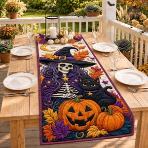 May include: A rectangular fabric table runner featuring a quilted design of a skeleton wearing a purple witch hat and cloak, a black cat, and orange pumpkins. The scene is decorated with colourful autumn leaves and a crescent moon on a light background.