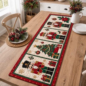 May include: A rectangular quilted table runner featuring a cream background with a red border. The design includes four panels depicting nutcrackers, a decorated Christmas tree, and wrapped gifts, accented with embroidered snowflakes and ornaments.