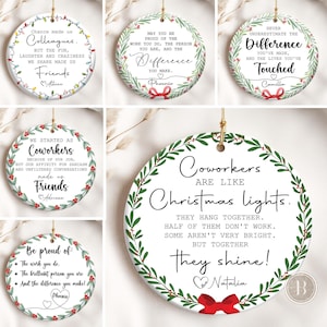 May include: Round white ceramic Christmas ornaments with gold hanging strings. Each ornament has a different message about friendship and colleagues, framed by a green wreath with red berries. Text includes "Colleagues", "Difference", and "Coworkers".
