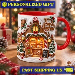 May include: A white ceramic mug with a red interior and handle, featuring a 3D-style gingerbread house design. The mug displays a gingerbread person, a sign reading Your Name, and a sign reading FRESH BAKED JOY, with festive holiday decor.