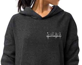 May include: A dark gray hooded sweatshirt with the text "bloom with grace" and a floral design embroidered on the front.