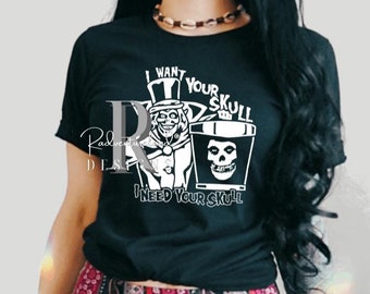 May include: Black t-shirt with a white graphic of a cartoon ghost wearing a top hat and holding a skull. The text "I want your skull I need your skull" is printed on the shirt.