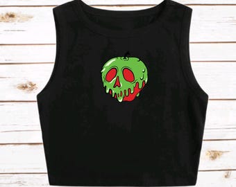 May include: Black sleeveless crop top featuring a green and red graphic of a skull-shaped apple. The apple design has red dripping from the bottom and is set against a black background. The top is made of a soft, comfortable material.