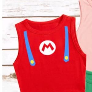 May include: Red crop top with blue suspenders and a white "M" logo, reminiscent of a popular video game character. The sleeveless top has yellow button details and is a vibrant, eye-catching design. A fun and playful garment.