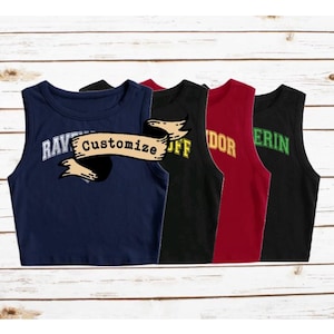May include: Four sleeveless crop tops in different colors with a banner across the front that says "Customize". The tops are navy blue, black, red, and black with a green design.