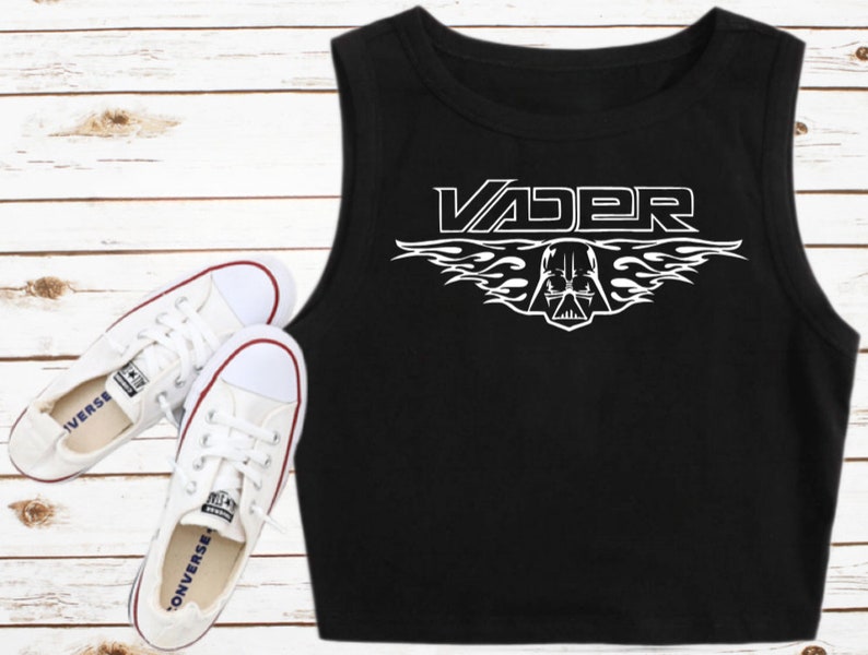 May include: Black sleeveless crop top with a white graphic of Darth Vader's helmet with flames and the word "VADER" above it.